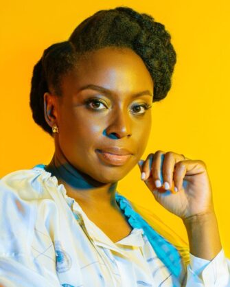Portrait of Chimamada Ngozi Adichie, Nigerian author, on a deep burnt yellow background