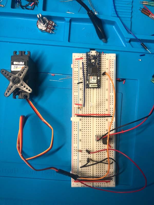 Arduino Nano 33 IoT in breadboard, circuit consisting of wire, 10k ohm resistor, phototransistor, and servo